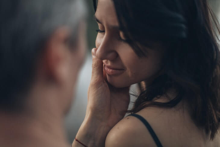 Man Embracing Face of Woman wit Eyes Closed