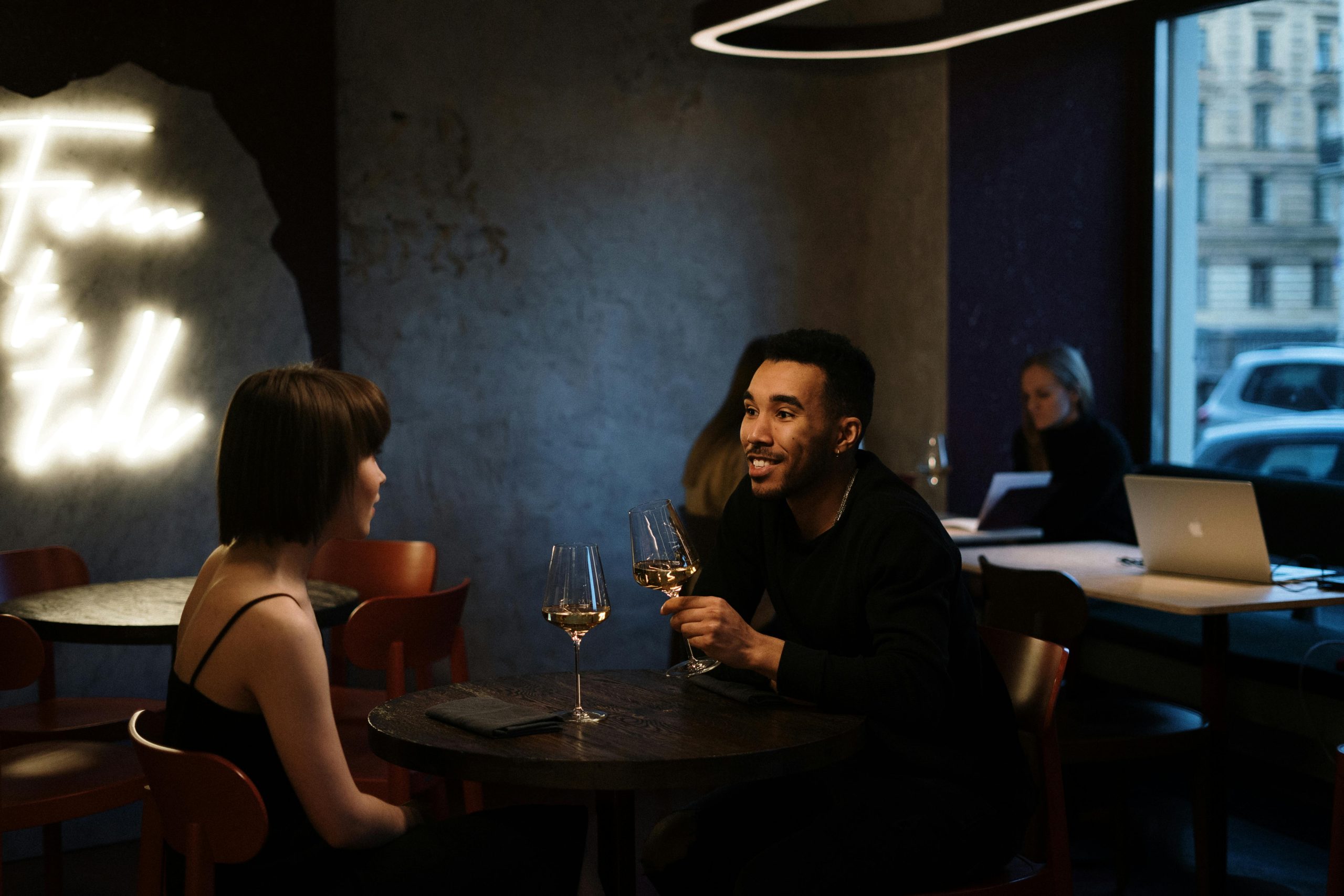 A man and woman on a date are toasting