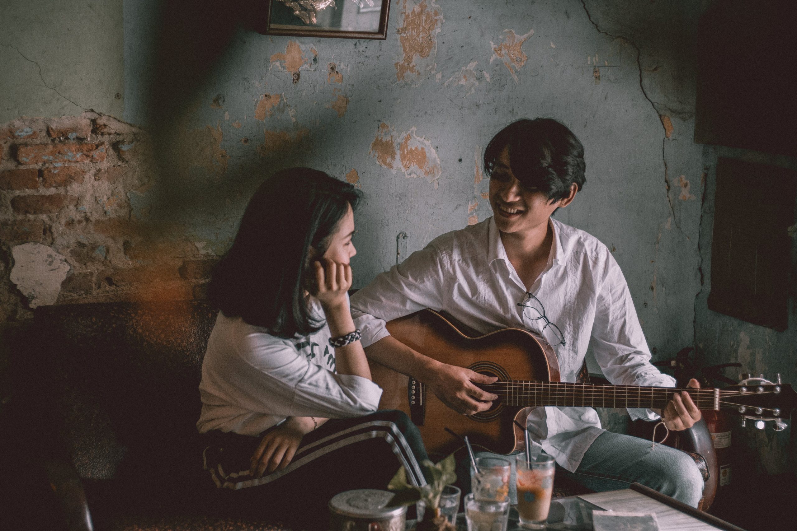 A boy is playing guitar for a girl